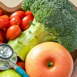 a stethoscope laying on top of a heart shaped bowl full of fruits and vegetables