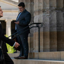 male lawmaker climbing steps of Capitol with a smile on his face