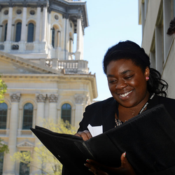 two lawmaker students looking over paperwork on the steps of the state capitol