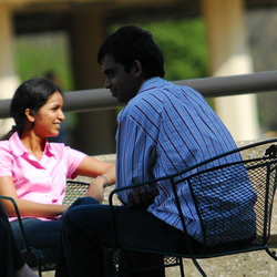 four students sitting out on the quad talking with each other