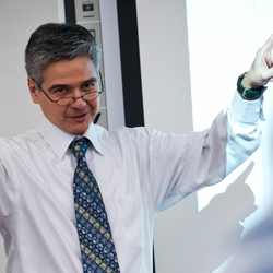 a male teacher teaching at the front of the classroom