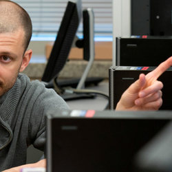 a professor showing a student something on a computer while they sit at a desk