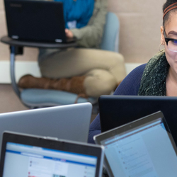  a group of women sitting in a circle with their laptops collaborating