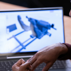 a person at their laptop with a computer design program up on the screen