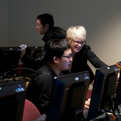 a professor explaining something on a computer to a student
