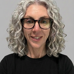 Professional photo of Dr. Kim Erbe wearing glasses and a black shirt.