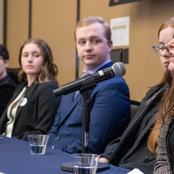 Group panel discussion with a woman speaking into a microphone.