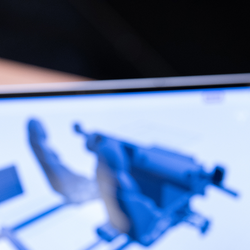 Person viewing 3D model on laptop screen.