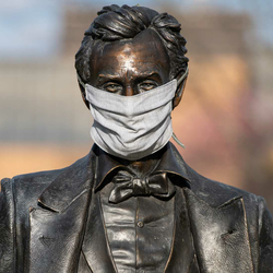 a statute of Abraham Lincoln on campus wearing a mask
