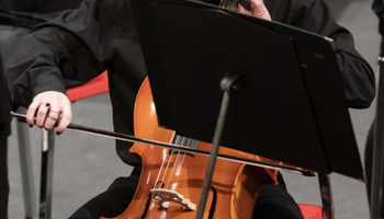 Cellist playing on stage, focused.