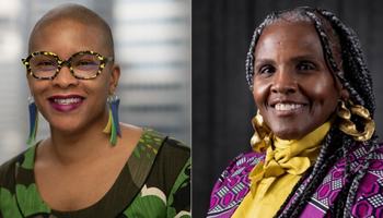 Two women smiling, one with glasses, bright earrings, and the other in a patterned outfit.