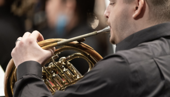 Musician playing a French horn.