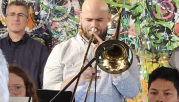 Student Musician performing in a concert holding a trombone.