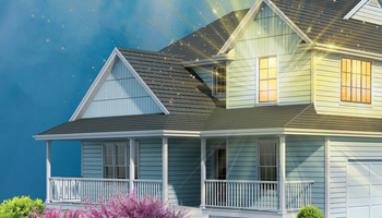 a blue suburban house with a light shining brightly out of one of its windows