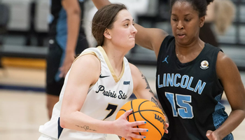 Kennedy Osterman playing basketball in white UIS uniform