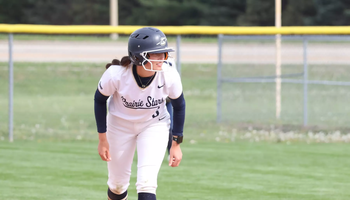 Jaden Watts playing softball in white UIS uniform