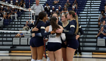 UIS Volleyball team in a huddle on the court