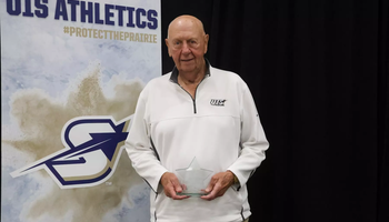 Phil Coady stands on stage with Prairie Star Pillar Award