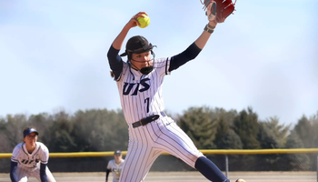 Rosie Bartletti pitching in white uniform