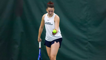 Jane Carter serving in UIS tennis match