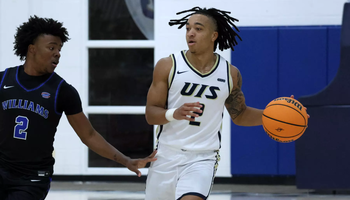 Jordan Rice playing basketball in white UIS uniform
