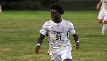 Brandon Djenebia playing soccer in white and gold UIS uniform