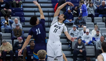 Donaven Younger jumping during tip-off at home UIS basketball game