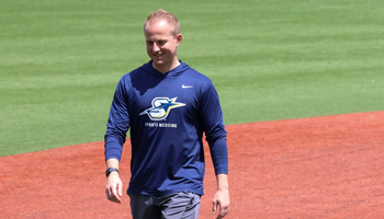 UIS Athletic Trainer Ryan Margold walking across baseball field