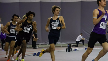 Charlie Borlin running indoor track at GLVC Championships