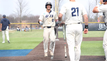 Noah Caceres celebrates hitting a home run in white UIS baseball uniform