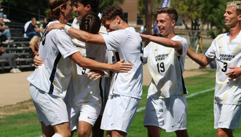 UIS men's soccer athletes in white UIS uniforms celebrate a goal