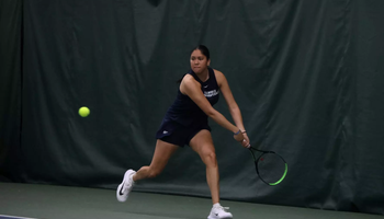 Cristina Mendoza Romero playing tennis in blue UIS uniform