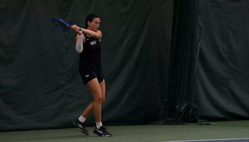 Ema Norma Bordean playing tennis in blue UIS uniform