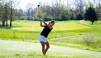 Lia Rody golfing in blue UIS gear