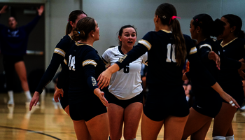 UIS Volleyball team huddle on the court
