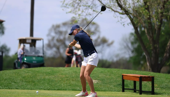 Elaine Grant golfing in blue UIS polo and hat
