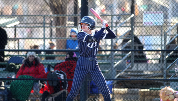Chloe Scroggins playing softball in blue UIS uniform