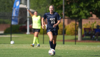 Abby Roy playing soccer in blue UIS uniform