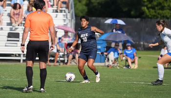 Ellie Mejia playing soccer in blue UIS uniform