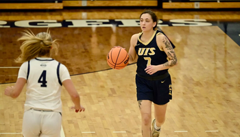 Kennedy Osterman playing basketball in blue UIS uniform