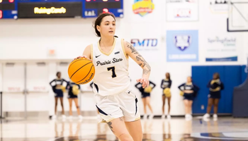 Kennedy Osterman playing basketball in white UIS uniform