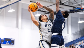 Tye Banks playing basketball in gray UIS uniform