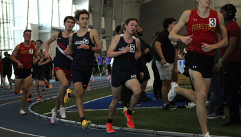 UIS men's track athletes running an indoor race