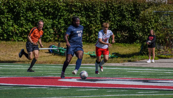 Nathan Oba-Okusanya playing soccer at away game in blue UIS uniform