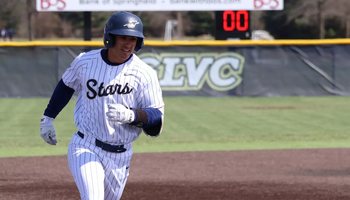 Tommy Atkinson rounding third  in white UIS baseball uniform