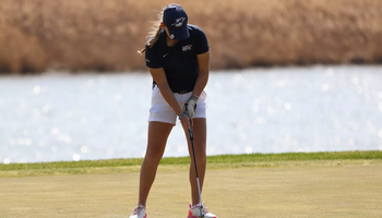 Elaine Grant golfing in blue UIS hat and polo