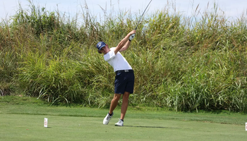 A photo of Jake Balding golfing in a white polo and blue hat