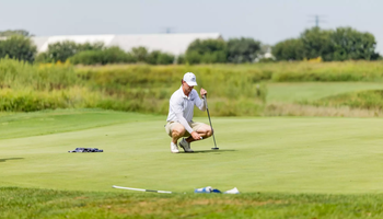 Jacob LeBlanc golfing in white UIS polo and hat