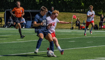 Josh Mensching playing soccer in blue UIS uniform