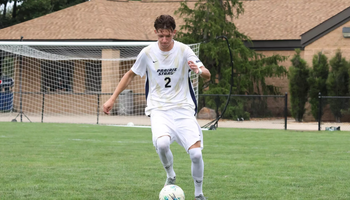 Lennard Borgs playing soccer in white UIS uniform